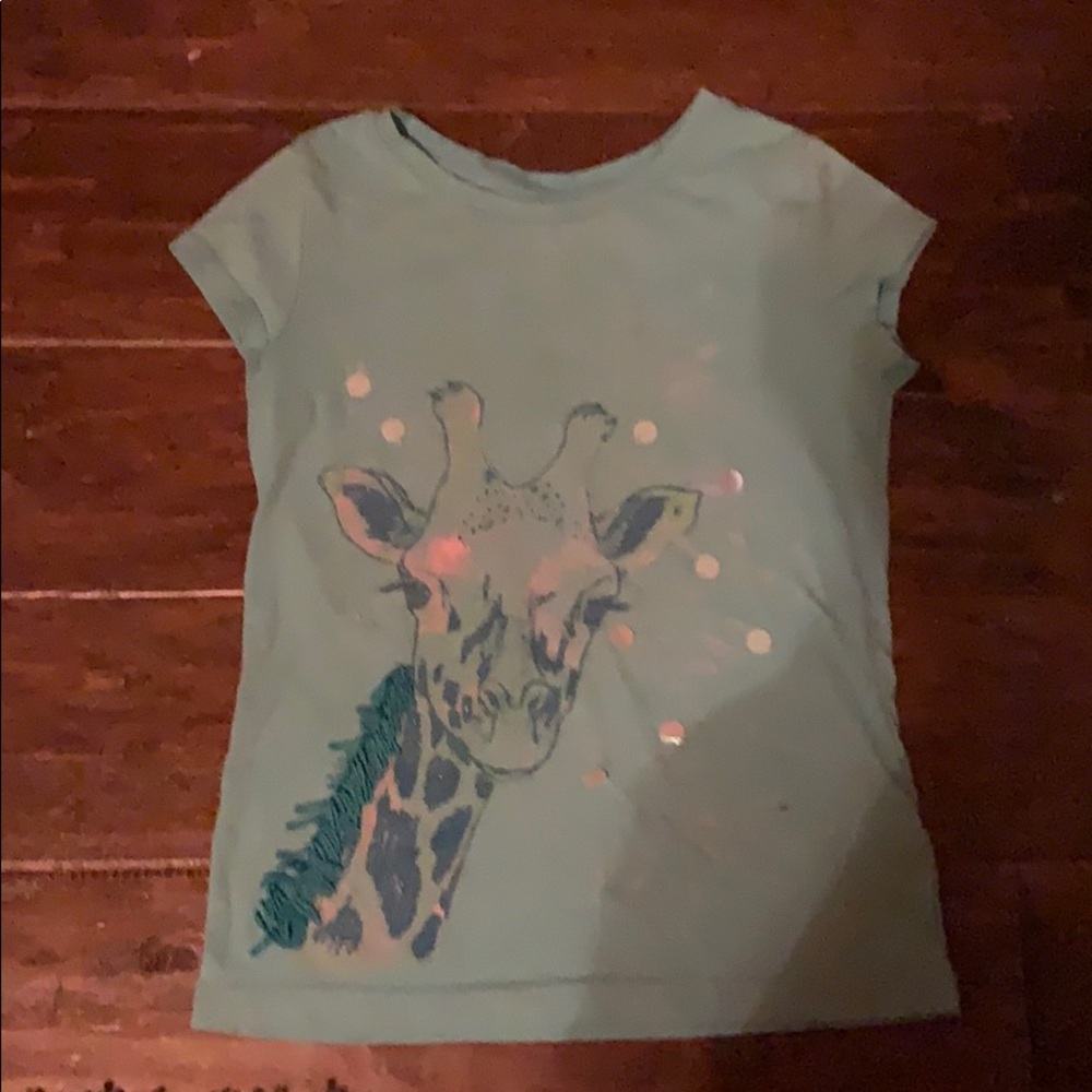 It is a blue shirt with a giraffe print on it